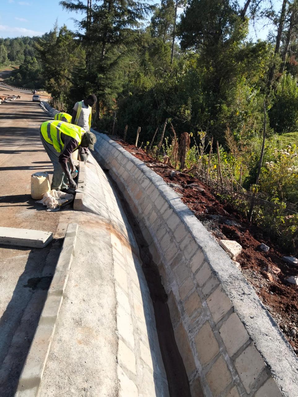 Finishing works to a lined roadside drainage channel